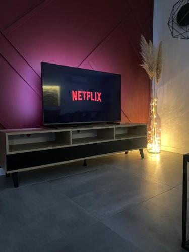 una televisione seduta sopra un tavolo di Magnifique grange avec spa / love room a Saint-André-de-Cubzac