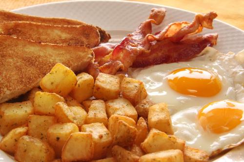 a plate of breakfast food with eggs bacon and toast at Holiday Inn East Windsor, an IHG Hotel in Hightstown