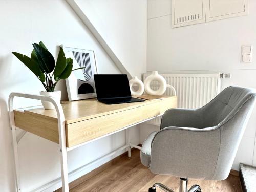 a desk with a laptop and a chair in a room at MyStay: *Travel & Business* in Nußloch