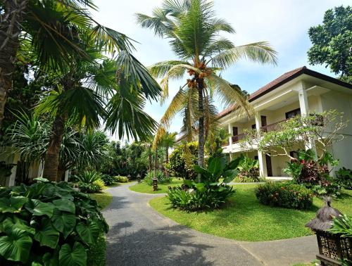 a path leading to a house with palm trees at Pertiwi Resort & Spa in Ubud