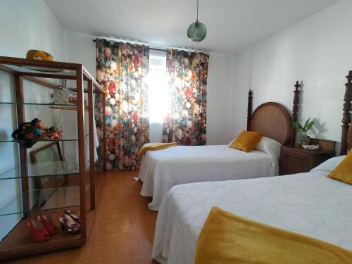 um quarto de hotel com duas camas e uma janela em Cerca de la playa, con bodega, terraza y jardin Camino Portugués em A Guarda