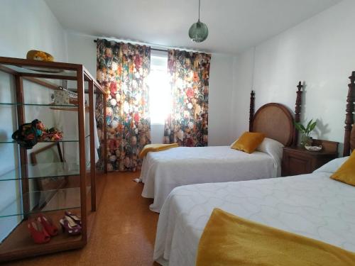 a hotel room with two beds and a window at Cerca de la playa, con bodega, terraza y jardin Camino Portugués in A Guarda