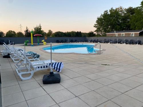 a swimming pool with lounge chairs and a playground at MORREALE MOBILE HOME (prox. Europa park/Rulantica) in Boofzheim