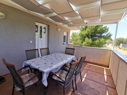 einen Tisch und Stühle auf dem Balkon eines Hauses in der Unterkunft Apartment Dundo in quiet green area in Medulin