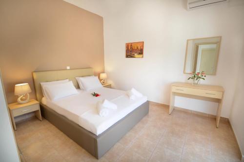 a bedroom with a large white bed and a mirror at Villa Silvia by Andrian Villas in Kalamítsion Alexándrou