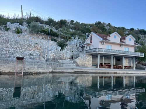 ポドゴリツァにあるLake Skadar Paradiseの水の横に座る家