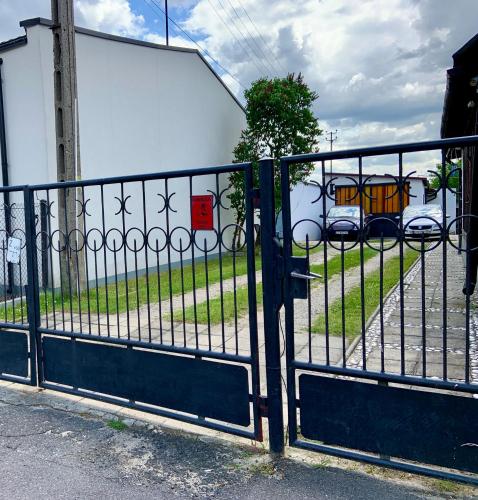 a black fence with a yellow bus in a parking lot at Cozy Independent guest apartment, free parking in Tomaszów Mazowiecki