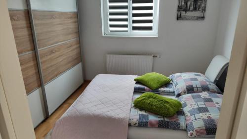 Cette petite chambre comprend un lit et deux oreillers verts. dans l'établissement Lalina, à Liezen