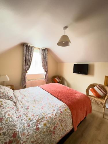 a bedroom with a bed and a tv on the wall at Clare Forest Apartment in Ballycastle