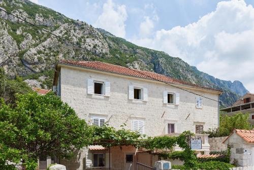 a large stone building with a mountain in the background at Konoba 224 Apartments in Kotor