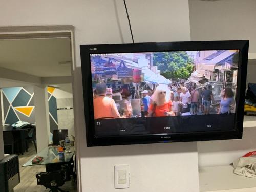 TV de pantalla plana colgada en la pared en Departamentos Patico en Santa Rosa de Calamuchita