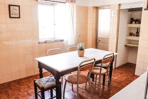 a kitchen with a table and chairs in a room at Golden Place - Seixal in Arrentela