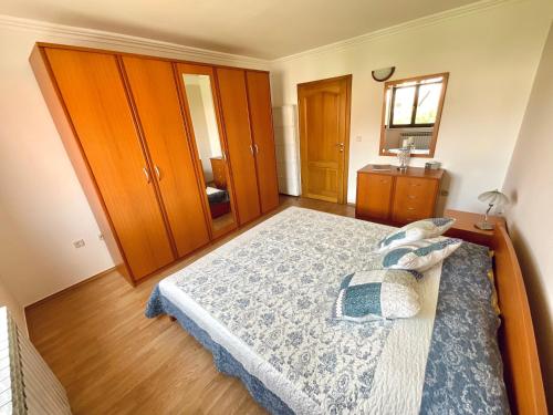 a bedroom with a large bed with wooden cabinets at Apartment Camellia 2 in Ljubuški