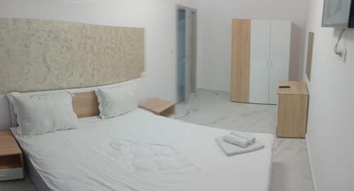 a bedroom with a bed with a white sheets and pillows at Iris Apartament Eforie Nord in Eforie Nord