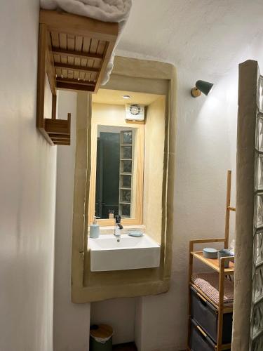 une salle de bain avec un lavabo et un miroir dans l'établissement La Source, à Saint-Saturnin-de-Lucian
