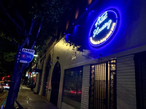 a blue neon sign on the side of a building at Artist Housing - Downtown in Los Angeles