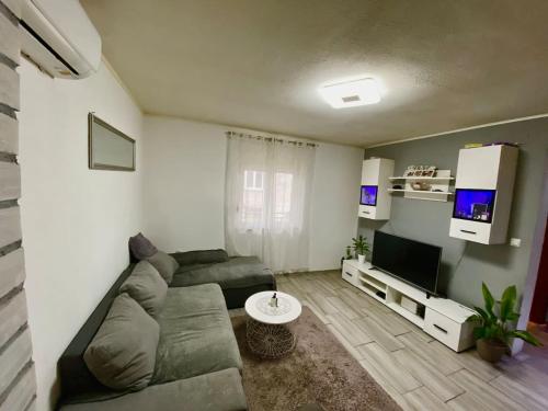 ein Wohnzimmer mit einem Sofa und einem Flachbild-TV in der Unterkunft DaMa in Kaštela