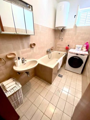 a bathroom with a sink and a tub and a toilet at DaMa in Kaštela