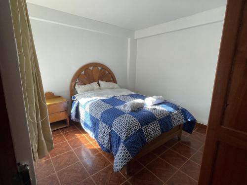 ein Schlafzimmer mit einem Bett mit einer blauen und weißen Decke in der Unterkunft Departamento Amoblado en el Centro de Cusco in Cusco