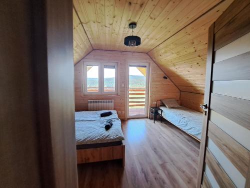 1 dormitorio con 2 camas en una casa de madera en Domki w Bieszczadach Nowa Zelandia, en Berezka