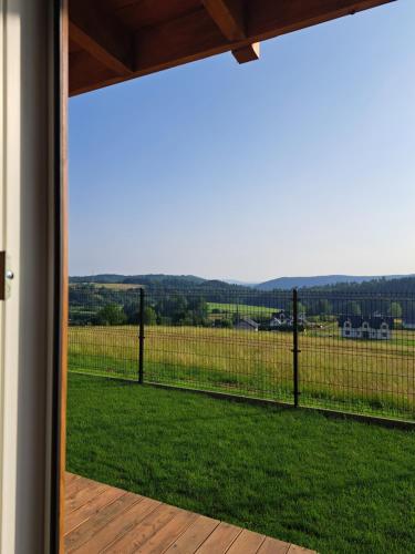 a view from the porch of a house with a fence at Domki w Bieszczadach Nowa Zelandia in Berezka