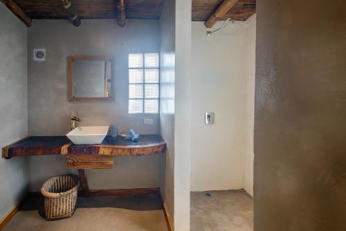 La salle de bains est pourvue d'un lavabo et d'un miroir. dans l'établissement Vistamar Guest House, à Ayampe