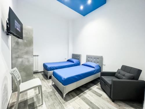 Zimmer mit 2 Betten, einem TV und einem Sofa in der Unterkunft Natola's Home Beach in Margherita di Savoia