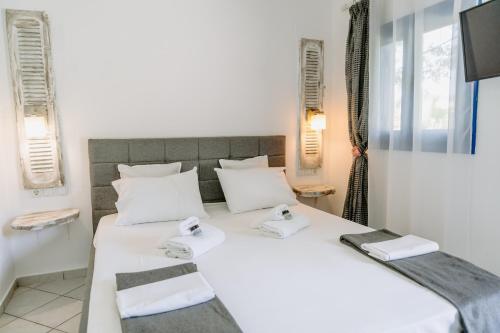 1 dormitorio con 2 camas y TV en Villa Marina, en Perdika