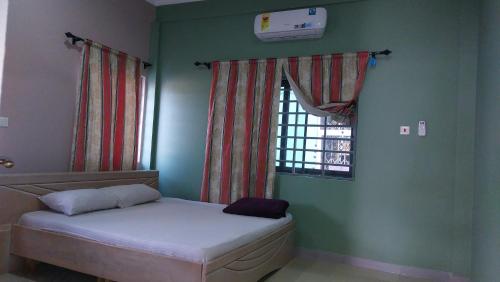 ein kleines Bett in einem Zimmer mit Fenster in der Unterkunft Affordable lovely apartment 3 in Accra