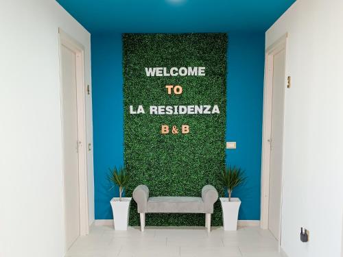a waiting room with a bench against a green wall at La Residenza B&B in Giba