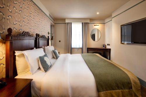 een hotelkamer met een groot bed en een televisie bij Morton Hotel in Londen