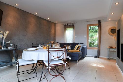 un salon avec une table, des chaises et un canapé dans l'établissement Gîte Contemporain L'hirondelle, à Guémar