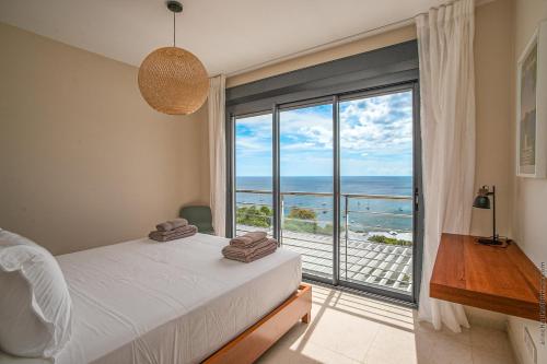 a bedroom with a bed and a view of the ocean at Villa Mahogany in Les Anses-dʼArlets