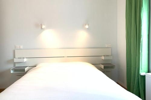 Una cama con dos luces encima en un dormitorio en Appart'Village Le Creusot N4 NeufNetflix, en Le Creusot