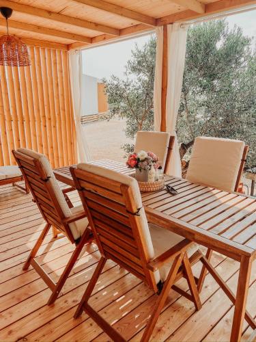 a wooden table and chairs on a wooden deck at Diamond Coast Mobile Home in Drage