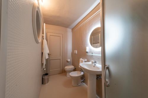 a white bathroom with a toilet and a sink at Palazzo Vergine - by Inside Salento in Gallipoli