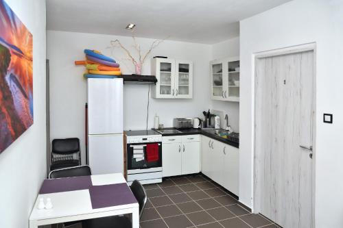 a small kitchen with white cabinets and a table at Water Lily Boutique B&B and Bungalow in Hévíz