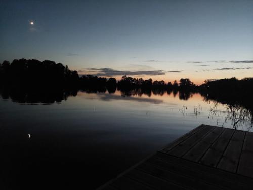 a view of a lake at sunset with the moon at Przystanek Dadaj in Najdymowo