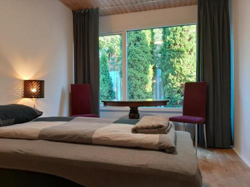 a bedroom with a bed and a large window at Sleep and Relax - Few minutes drive to the Ferry, Lalandia and the Femern Tunnel project in Rødby