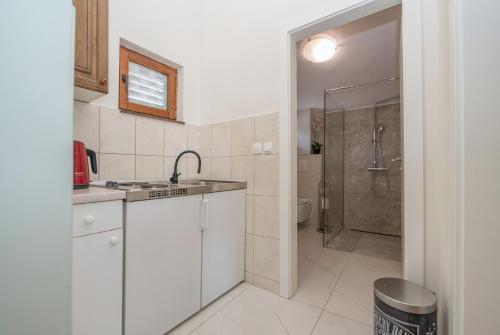 馬卡爾斯卡的住宿－Apartman Marin，白色的厨房设有水槽和淋浴