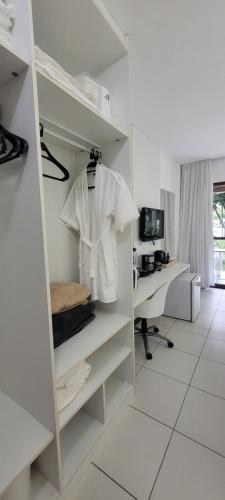 uma camisa branca está pendurada numa prateleira num quarto em ILOA Residence Flat Alagoas na Barra de São Miguel