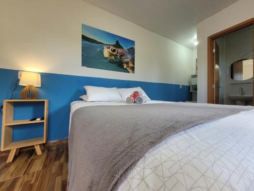 ein Schlafzimmer mit einem großen Bett mit blauer Wand in der Unterkunft Batera House Noronha in Fernando de Noronha
