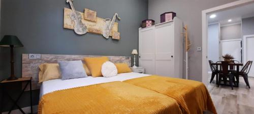 1 dormitorio con 1 cama con manta amarilla en Cruces Hospital Metro, en Barakaldo