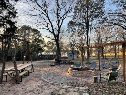 a park with benches and a fire pit and trees at Lake home on 3 acres in Mabank