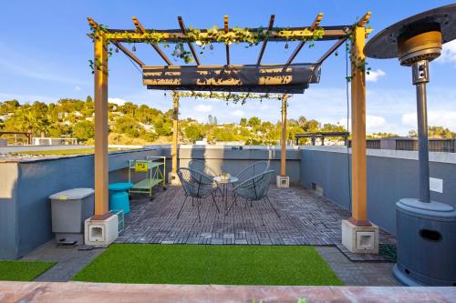 a patio with a table and chairs on a roof at Chic Silver Lake Oasis with Private Rooftop, Breathtaking Panoramic DTLA Views & Private Garage in Los Angeles