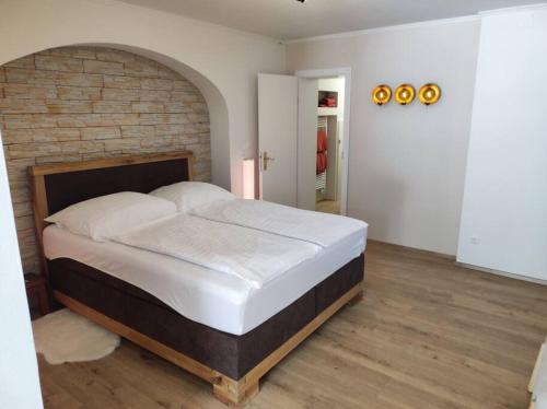 uma cama grande num quarto com uma parede de tijolos em Ferienappartement 2 beim Strandbad em Reifnitz