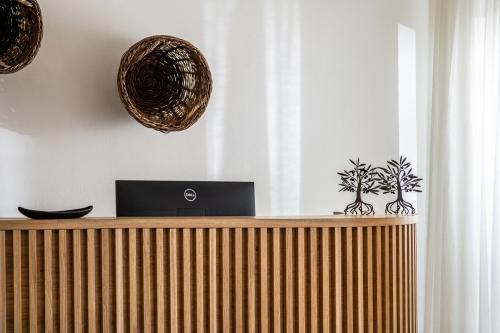 a wooden counter with a laptop on top of it at Elea Suites & Residences in Gouves