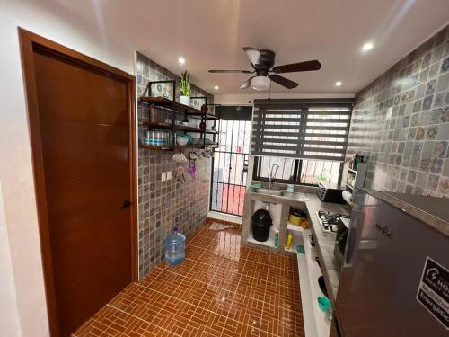 a kitchen with a ceiling fan and a tile floor at Casa Santa Cruz in Chetumal