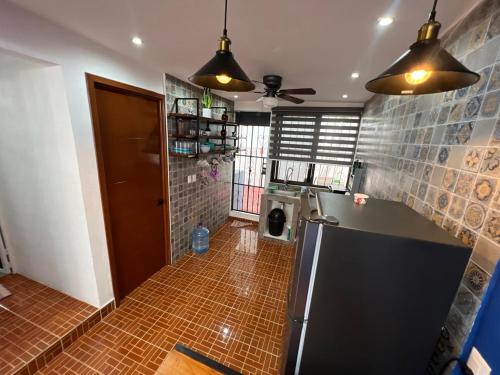 a kitchen with a refrigerator and a tile floor at Casa Santa Cruz in Chetumal