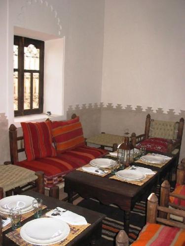 a living room with couches and tables with plates at Dar Sihamou in Tabant